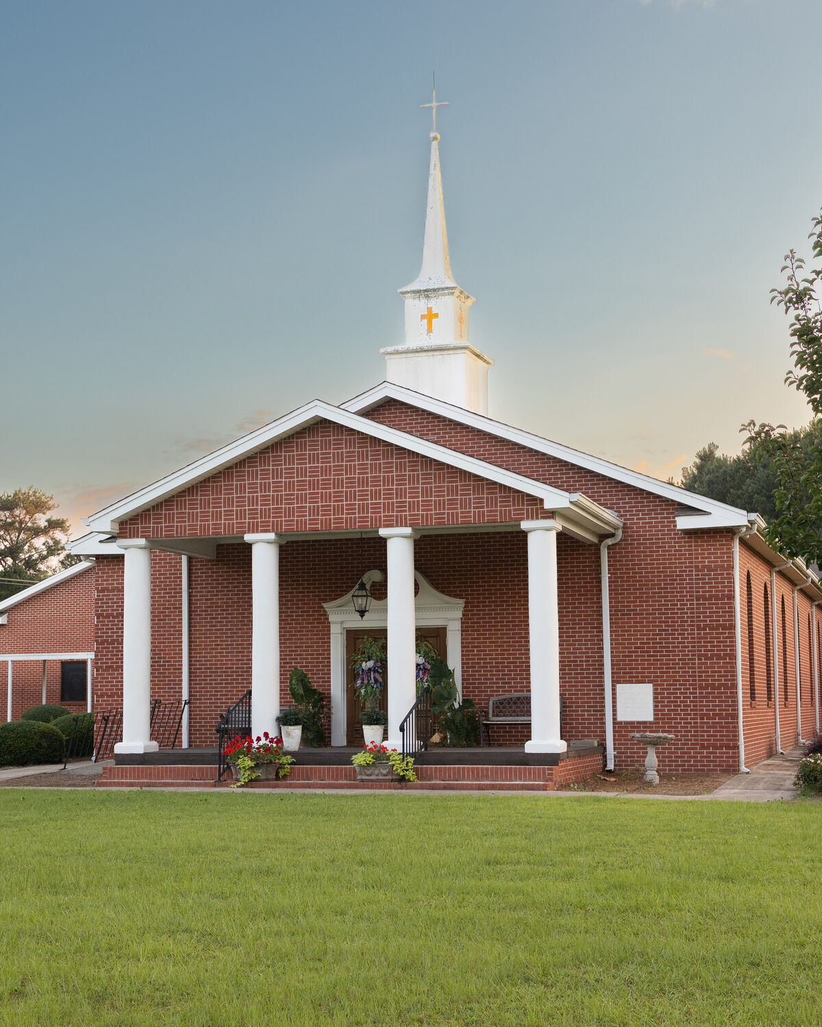 Front porch and steeple of Pleasant Grove Baptist Church at sunset